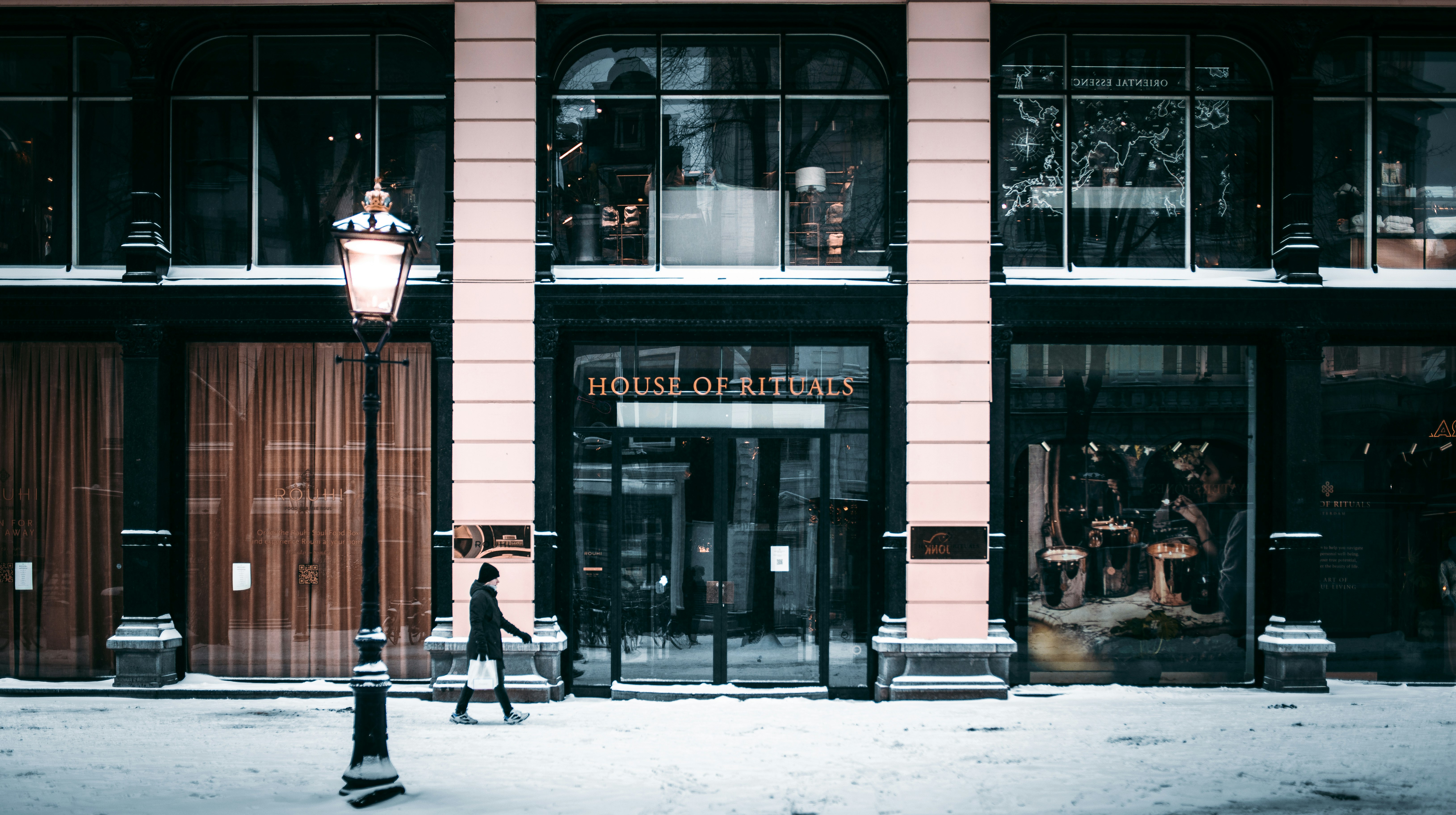 man in black coat walking on sidewalk during daytime